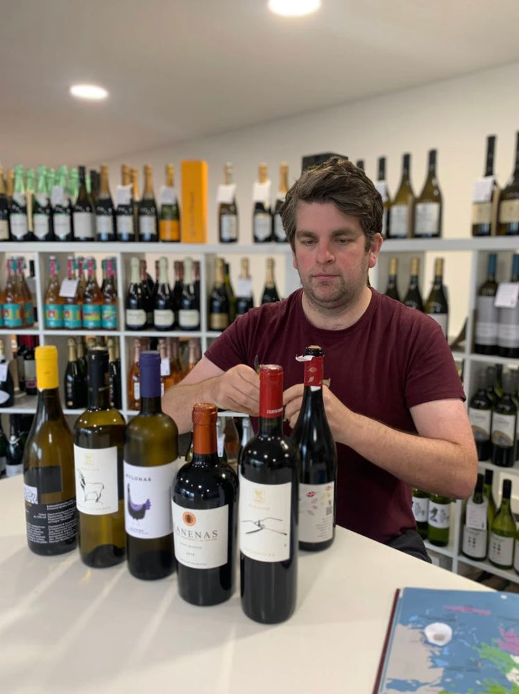 The owner Luke Flunder is surrounded by bottles of Greek wine and he is ready for a wine tasting session