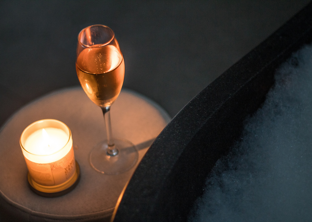 Serene shot of a glass of white wine next to a lighted candle